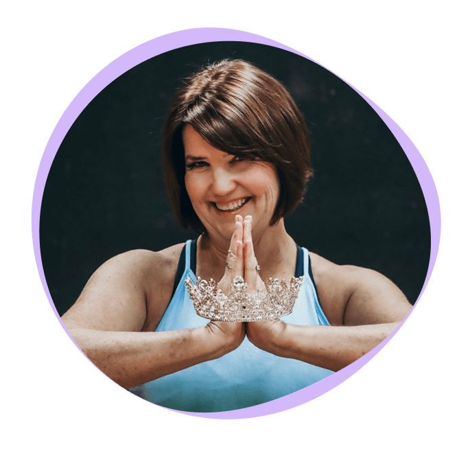 Woman in a blue tank top holds a jeweled crown between her palms, smiling, with a purple circular border framing the image.